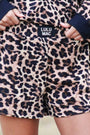 Leopard print shorts with navy cuffs and 'LULU MAC' label on a blurred background