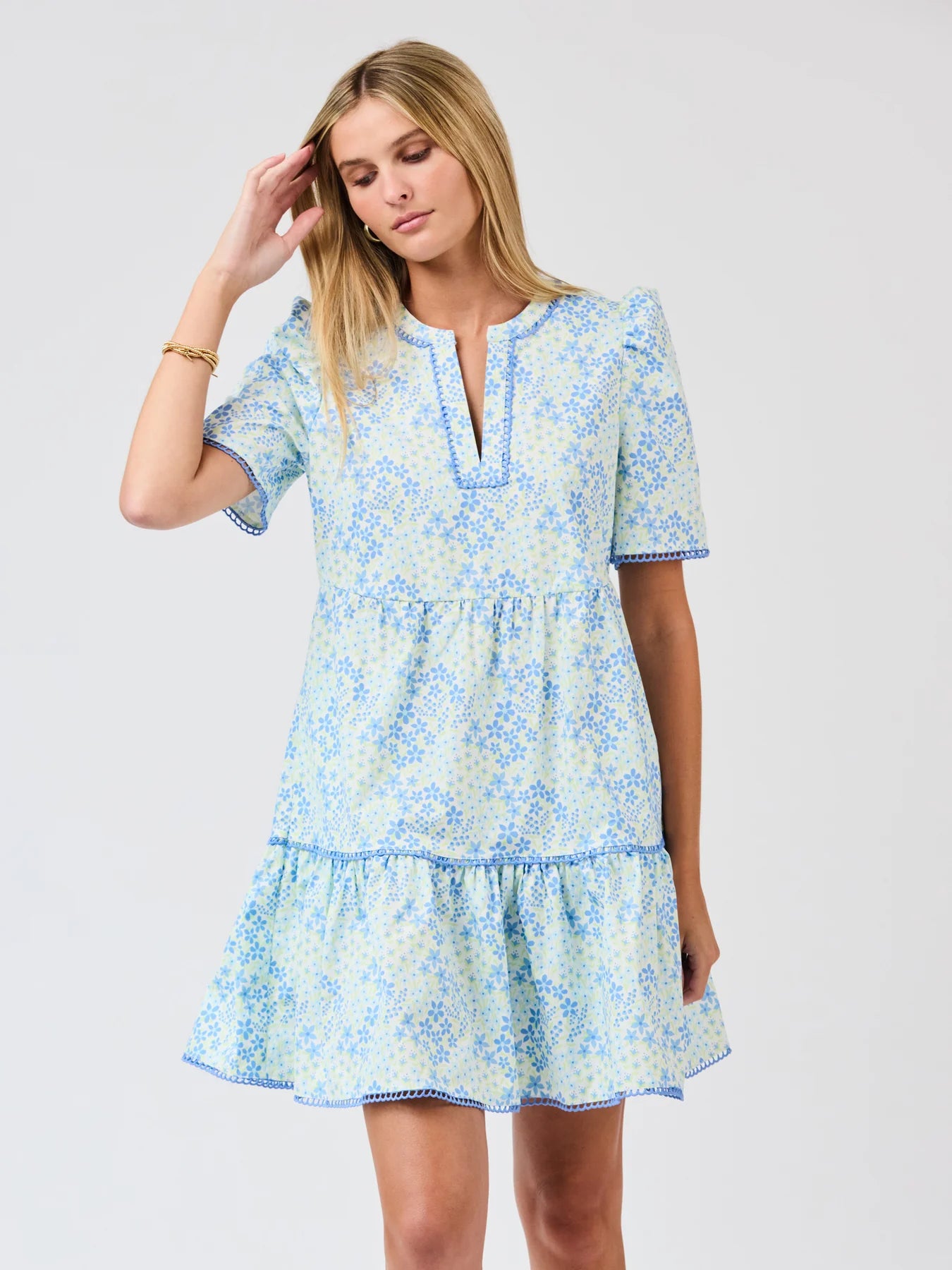 Woman wearing a light blue floral dress on a white background