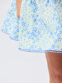 Close-up of a floral dress with blue and green pattern on a white background
