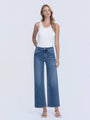 Woman wearing a white tank top and blue jeans on a white background