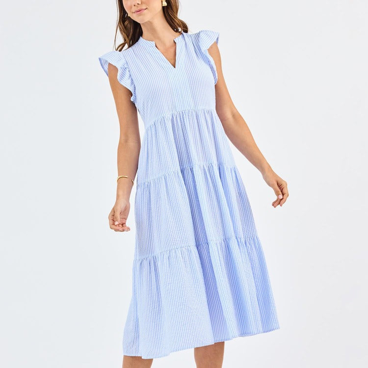 Woman wearing a light blue striped dress on a white background