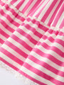 Close-up of pink and white striped fabric with a frayed edge.