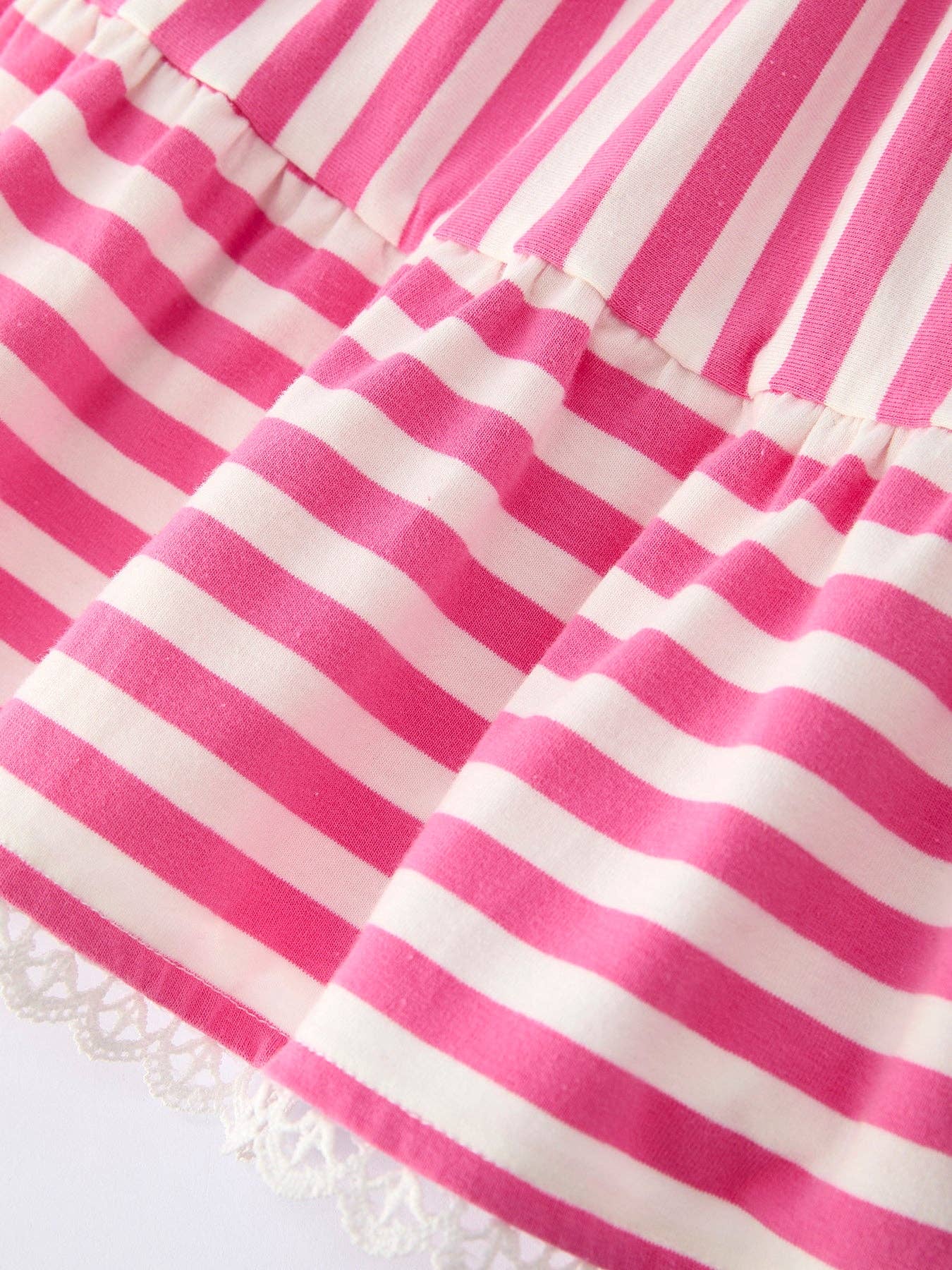 Close-up of pink and white striped fabric with a frayed edge.