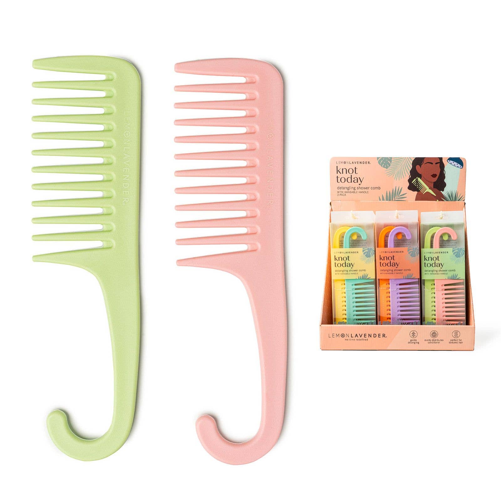 Two combs, one green and one pink, with a box of hair products in the background on a white background.