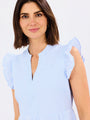 Woman wearing a light blue striped dress against a white background