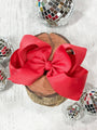 Red bow on a wooden block with disco balls in the background