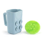 Blue mug with a handle and a green silicone ball on a white background