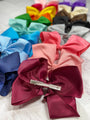 Colorful hair bows with a hair clip on a light background