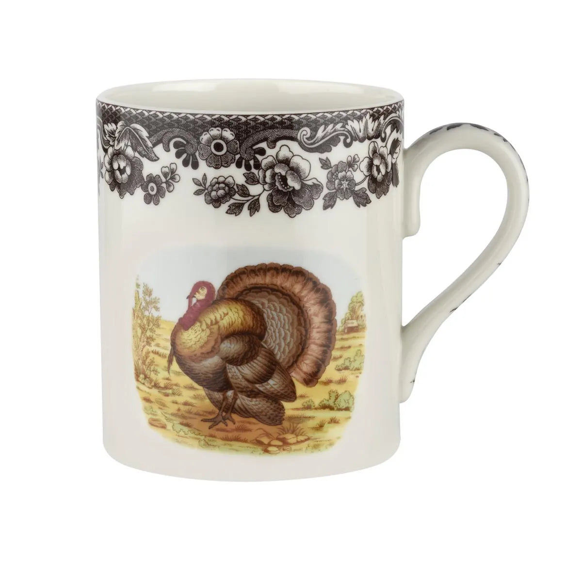 A white ceramic coffee mug featuring a black floral border pattern and a central illustration of a brown and gold turkey on a yellow background.