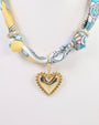 Necklace with a heart-shaped pendant and colorful scarf on a white background