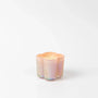 Iridescent candle holder with a candle inside on a white background