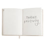 Open devotional book with handwritten-style words 'gratitude' and 'positive' on pages