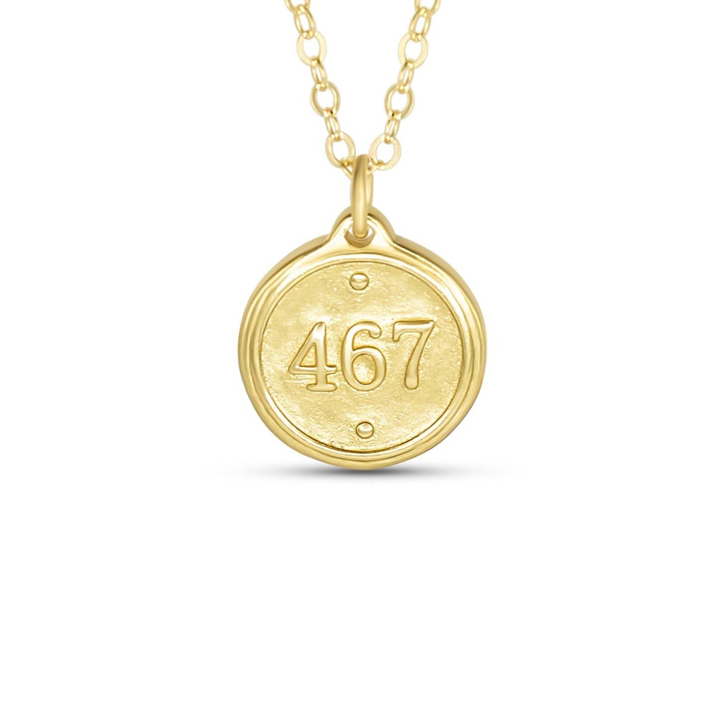 Gold necklace with a round pendant displaying the number 467 on a white background