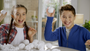 Two children playing with snowballs indoors, smiling and having fun.