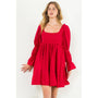 Woman wearing a red dress with puff sleeves on a white background