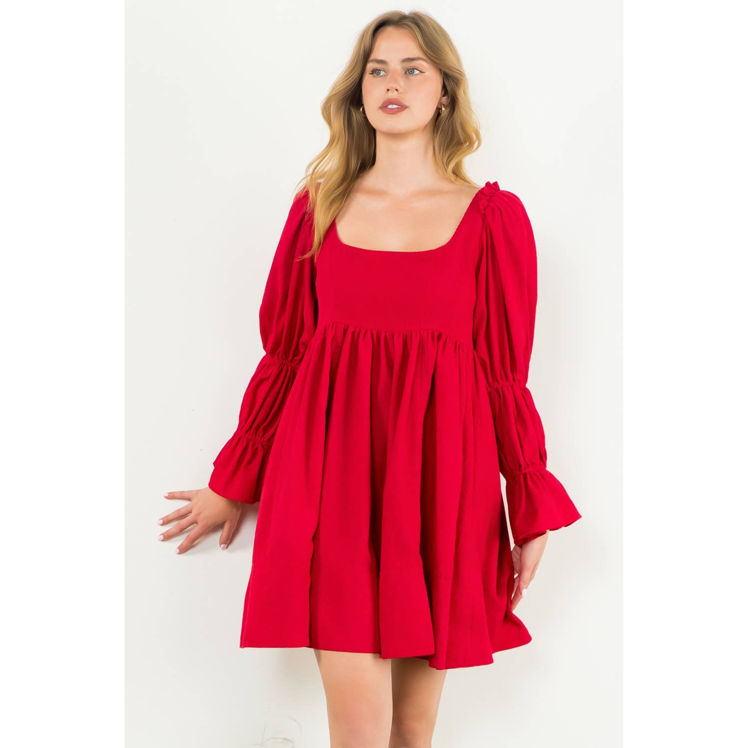 Woman wearing a red dress with puff sleeves on a white background