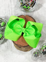 Two bright green bows on a wooden block with disco balls around