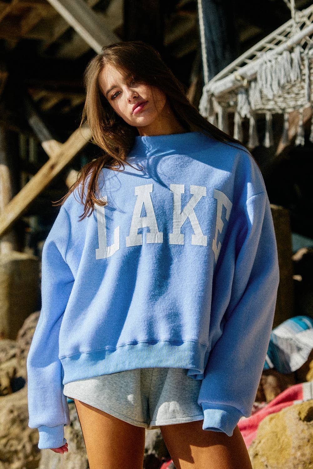 Person wearing a blue sweatshirt with 'LAKE' text, standing outdoors.