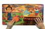 Children's book with colorful illustrations of a scarecrow, birds, and a tiger on a wagon, held open by two hands.