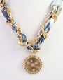 Necklace with gold chain and decorative pendant on a white background