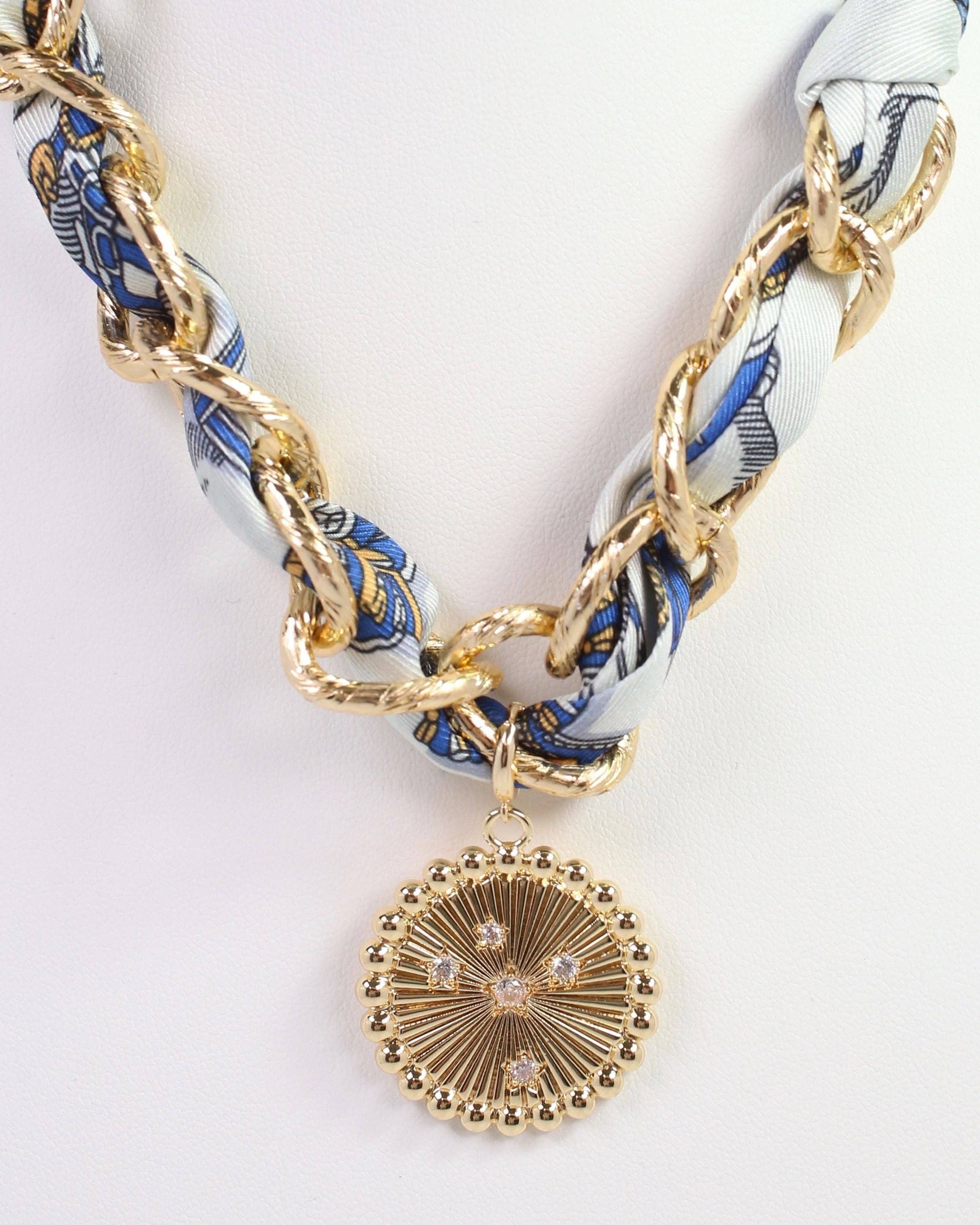 Necklace with gold chain and decorative pendant on a white background