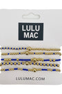 Set of gold and blue beaded bracelets on a Lulu Mac packaging with website URL.