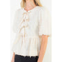 White textured vest with ruffled details worn by a person on a white background
