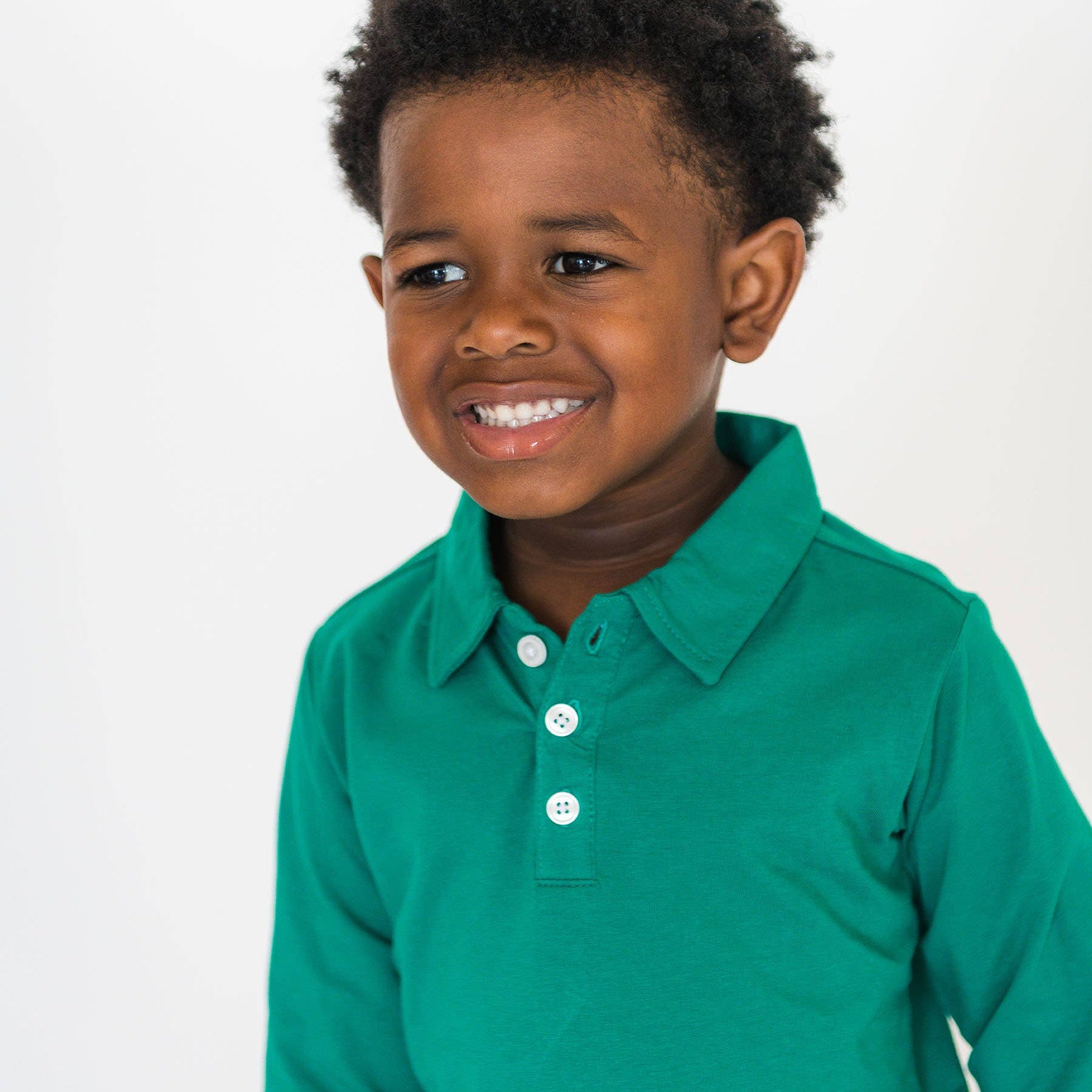 Child wearing a green long-sleeve shirt on a white background