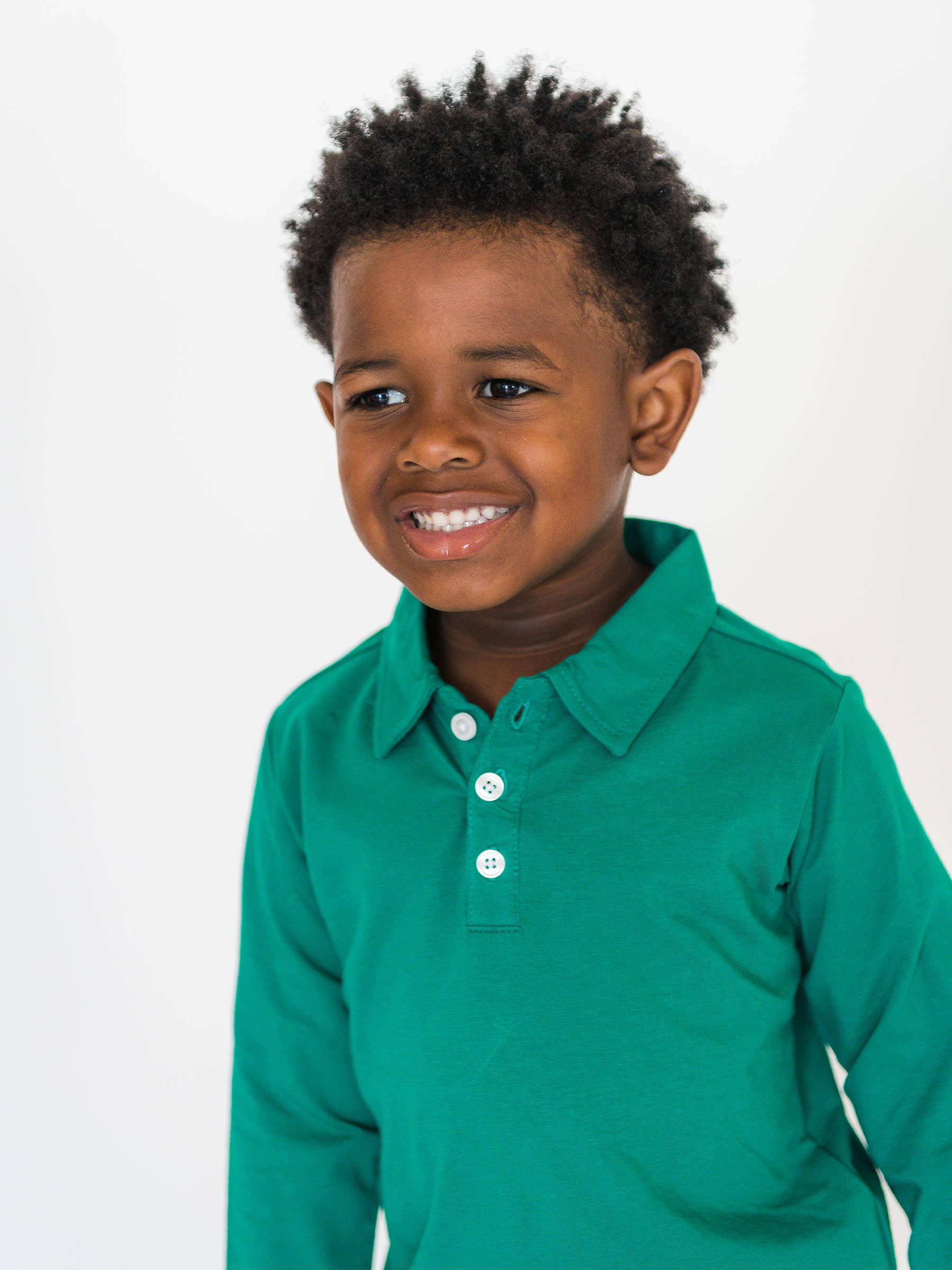 Child wearing a green long-sleeve shirt on a white background