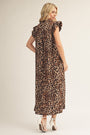 Woman wearing a leopard print dress on a plain background