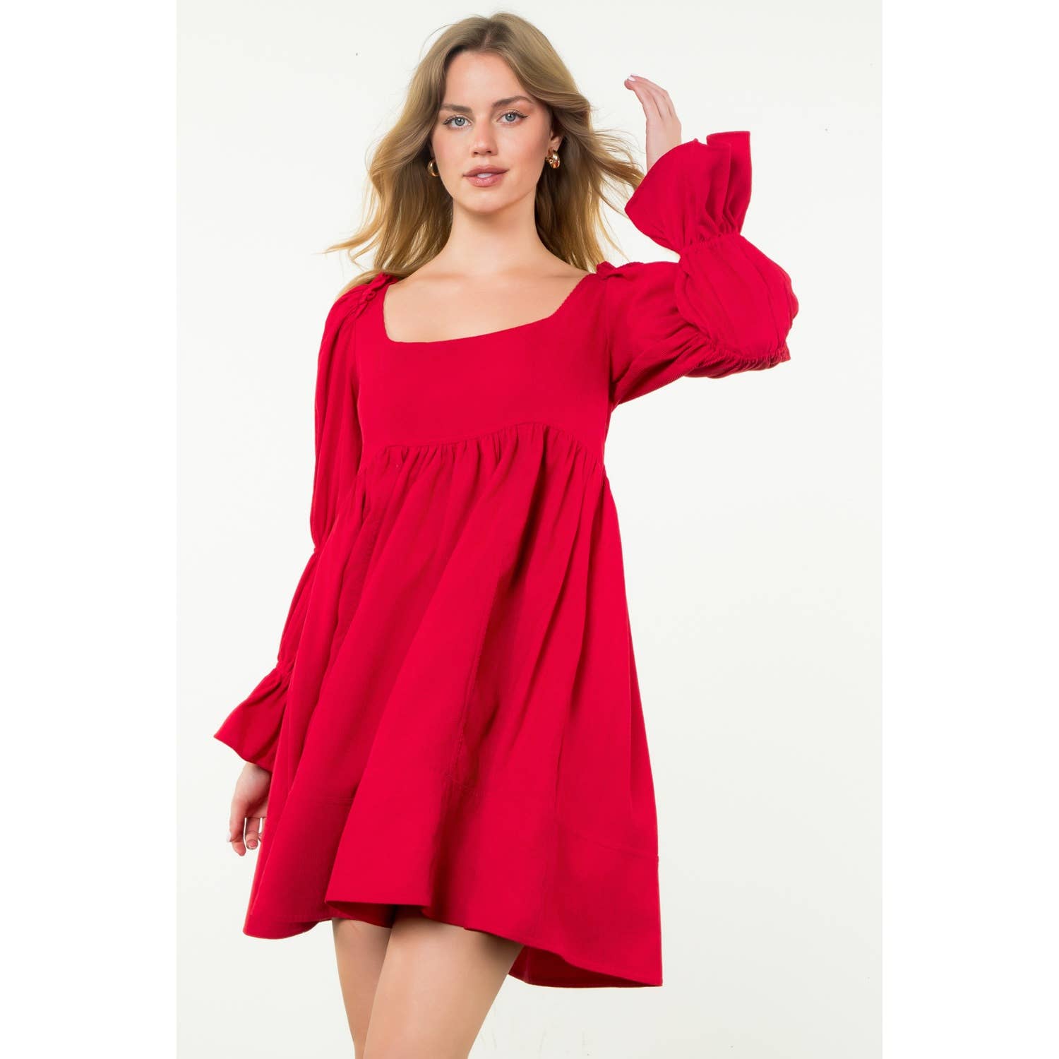 Woman wearing a red dress with long sleeves on a white background