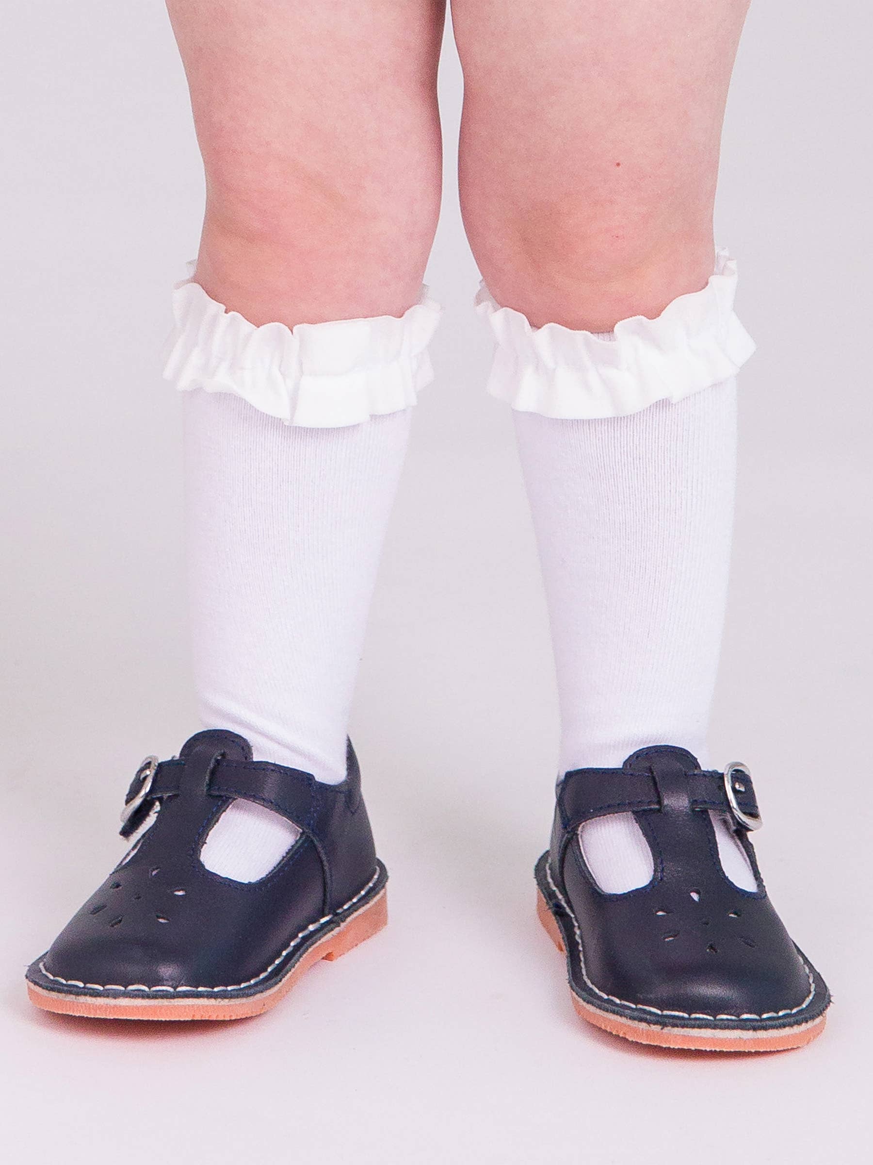 Navy blue shoes with white socks on a plain background