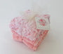 Pink textured baby booties with a brand tag on a white background