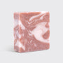 Marbled pink and white soap bar on a light gray background
