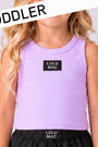 Child wearing a purple tank top and black shorts with LULU MAC branding on a light  gray background.