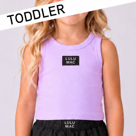 Child wearing a purple tank top and black shorts with LULU MAC branding on a light  gray background.