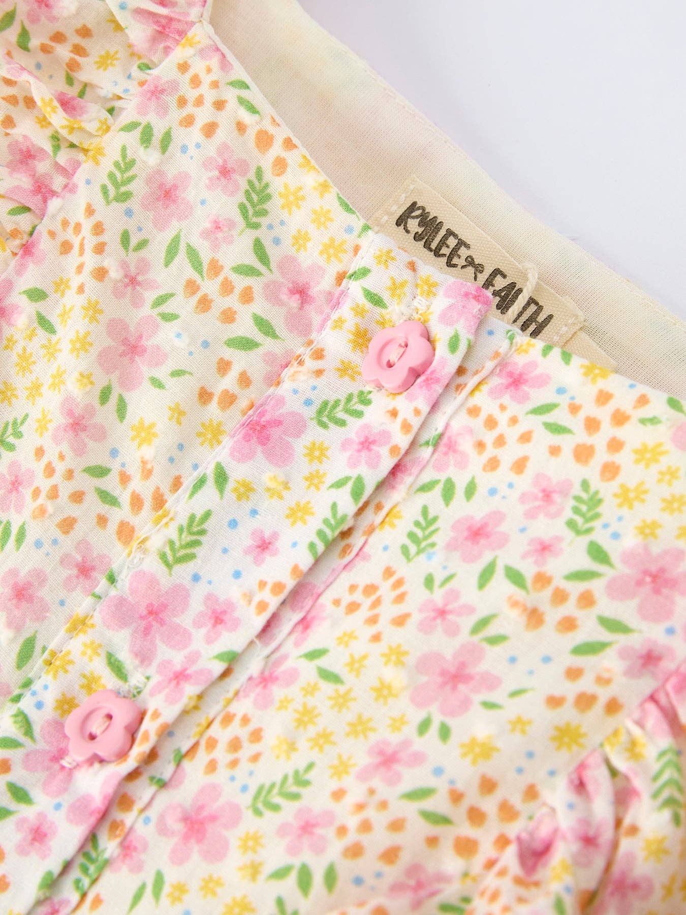 Floral-patterned fabric with a brand name on a white background