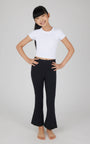 Person wearing a white crop top and black pants on a plain background