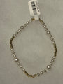 A beaded necklace with white faux pearls and small metallic gold beads, shown on a light gray textured background with a white barcode tag attached.