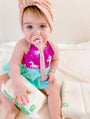 Baby with pacifier wearing a linen clip attached to outfit