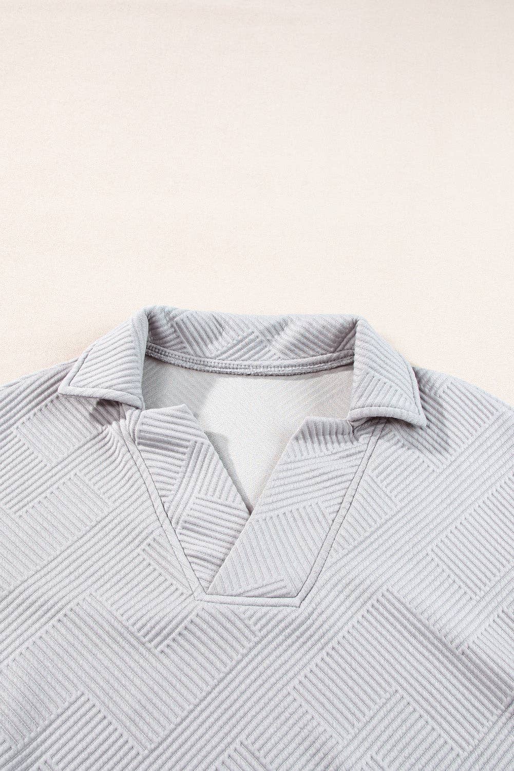 Light gray textured shirt on a light beige background