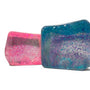 Two glittery rectangular objects, one pink and one blue, on a white background.