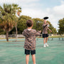Two people playing with a frisbee on a tennis court