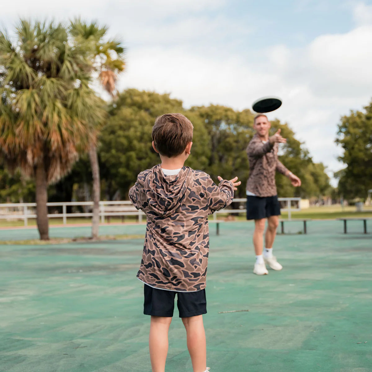 Two people playing with a frisbee on a tennis court