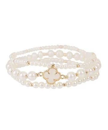 A multi-strand pearl bracelet with a gold-tone clover-shaped charm, displayed on a clean white background.