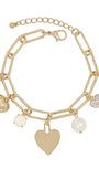 A gold-tone chain bracelet with multiple dangling charms, including heart-shaped pendants, a textured disc charm, a pearl bead, and a rhinestone-encrusted heart charm, shown on a plain white background.