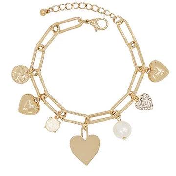 A gold-tone chain bracelet with multiple dangling charms, including heart-shaped pendants, a textured disc charm, a pearl bead, and a rhinestone-encrusted heart charm, shown on a plain white background.
