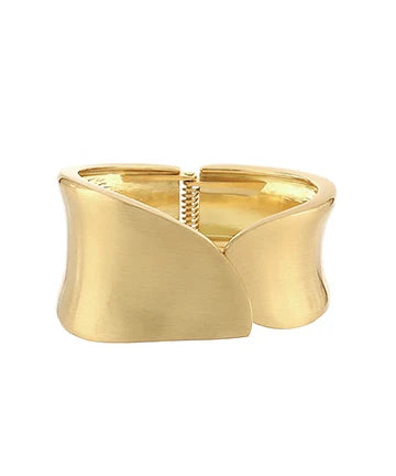 A wide, open cuff bracelet in polished yellow gold, featuring a sculptural, wavy, wing-like design with a textured spring clasp in the center, shown on a plain white background.
