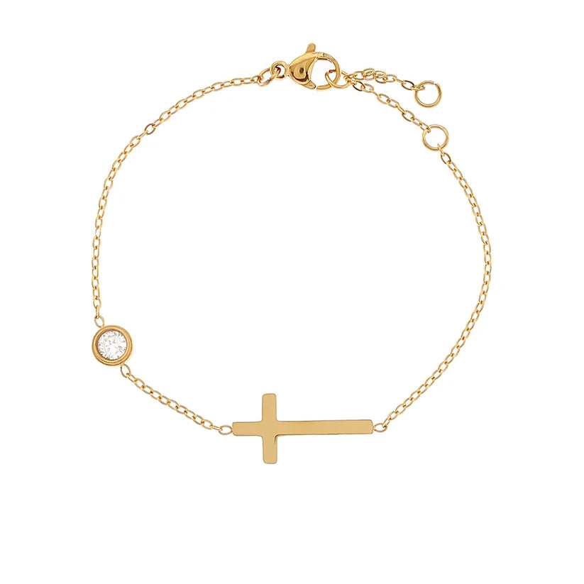 Gold bracelet with a cross and small round charm on a white background