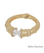 Gold bracelet with pearls on a white background